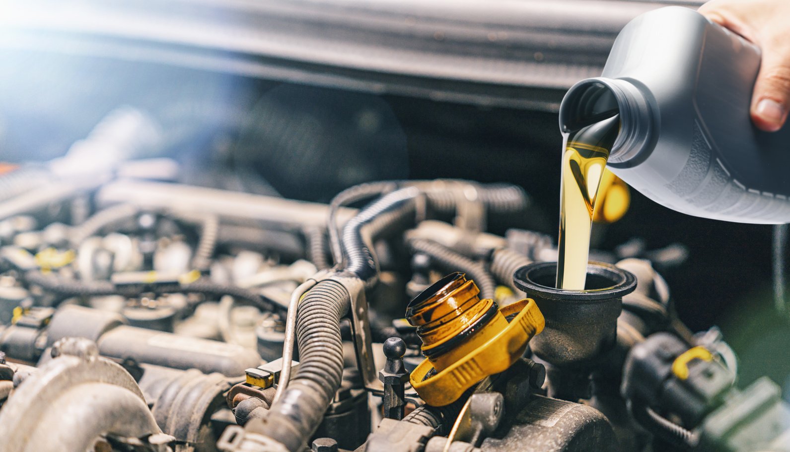 Pouring Oil to Car Engine. Fresh Motor Oil Poured during an Oil